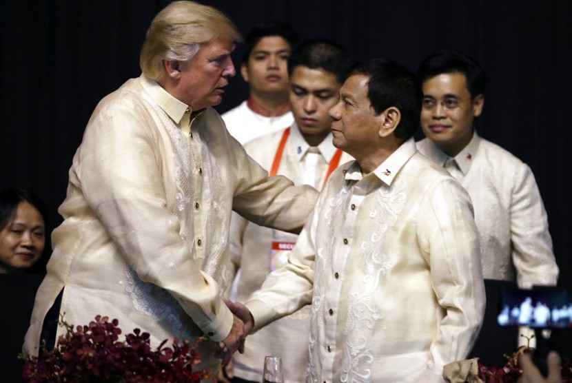 Presiden AS Donald Trump berjabat tangan dengan Presiden Filipina Rodrigo Duterte saat makan malam KTT ASEAN di SMX Convention Center, Ahad (12/11).