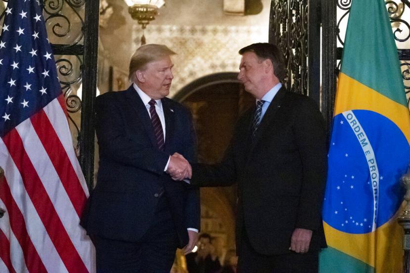 Presiden AS Donald Trump bersalaman dengan Presiden Brasil Jair Bolsonaro saat melakukan pertemuan di Florida, Amerika Serikat, pada 7 Maret 2020.(AP Photo/Alex Brandon)