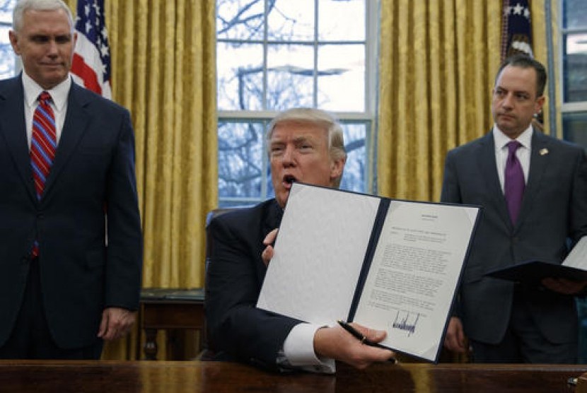 Presiden AS Donald Trump didampingi Wakil Presiden Mike Pence (kiri) usai menandatangani perintah eksekutif keluarnya AS dari Kemitraan Trans-Pasifik pada 23 Januari 2017.