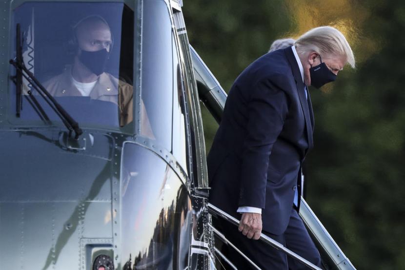  Presiden AS Donald Trump keluar dari helikopter Marine One saat tiba di  Walter Reed National Military Medical Center di Bethesda, Maryland, pada Jumat (2/9). Trump akan dirawat selama beberapa hari ke depan setelah positif Covid-19.