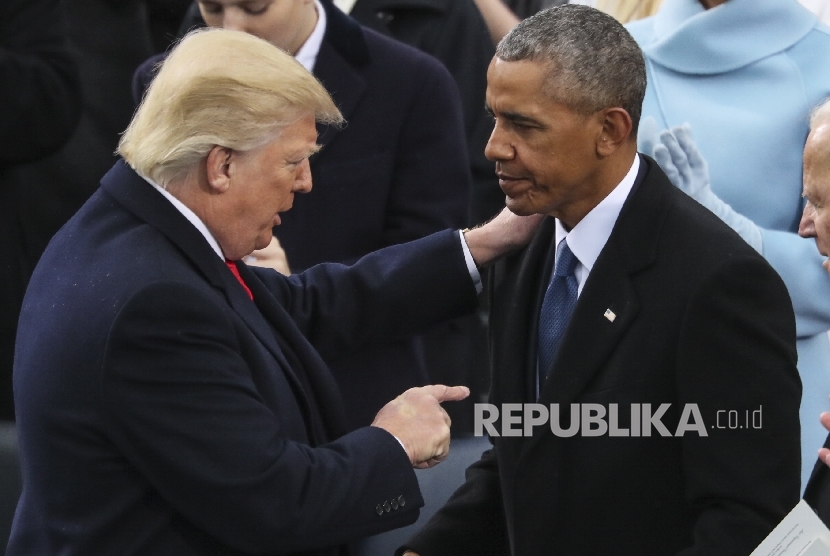 Presiden AS Donald Trump menunjuk barack Obama seusai upacara inagurasi di Gedung Capitol, Washington DC, Jumat (20/1).