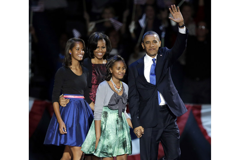 Presiden Barack Obama didampingi keluarganya melambaikan tangan kepada para pendukungnya usai berpidato di Chicago, Rabu (7/11).   (AP/Charles Rex Arbogast)