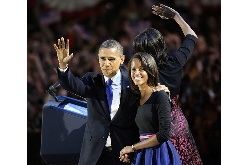 Presiden Barack Obama melambaikan tangan bersama putrinya Malia usai berpidato di Chicago, Rabu (7/11). (AP/Charles Rex Arbogast)
