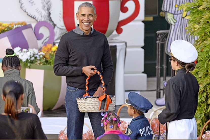 Presiden Barack Obama membagikan permen sambil bernyanyi saat merayakan Halloween