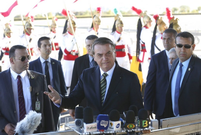 Presiden Brasil Jair Bolsonaro (tengah) berbicara pada wartawan di luar kediaman resmi kepresidenan Alvorada Palace, Brasilia, Brasil, Selasa (27/8).