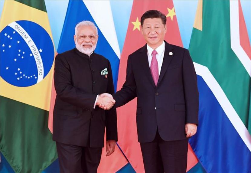 Presiden China Xi Jinping (kanan) dan Perdana Menteri India Narendra Modi (kiri) berfoto dalam KTT BRICS. Keduanya akan bertemu pertama kali sejak bentrokan di perbatasan 