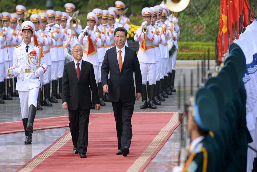 Presiden Cina, XI Jinping (kanan) dan Sekjen Partai Komunis Vietnam, Nguyen Phu Trong (tengah), berjalan dalam upacara penyambutan di Istana Presiden, Hanoi, Vietnam, Kamis (5/11). 