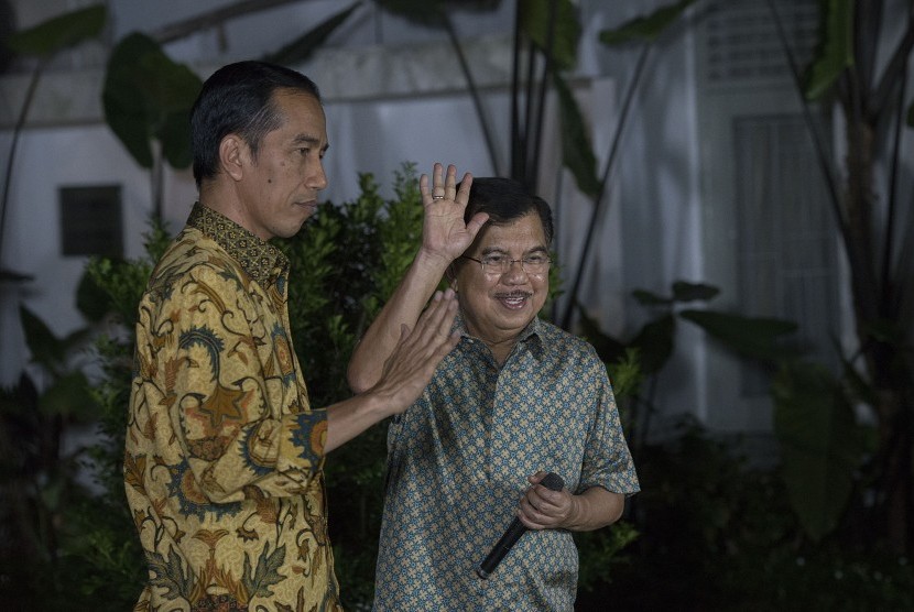 Presiden dan Wakil Presiden terpilih, Joko Widodo (kiri) dan Jusuf Kalla (kanan) melambaikan tangan usai memberikan konferensi pers di halaman Rumah Dinas Gubernur DKI Jakarta di Taman Suropati Nomor 7, Jakarta, Kamis (21/8) malam. 