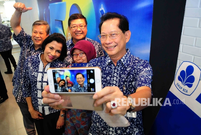 Presiden Direktur BCA, Jahja Setiaatmadja (kanan) berfoto 'selfie' bersama dengan jajaran direksi BCA saat menggelar syukuran ulang tahun BCA ke-59 di Menara BCA, Jakarta, Jumat (26/2).