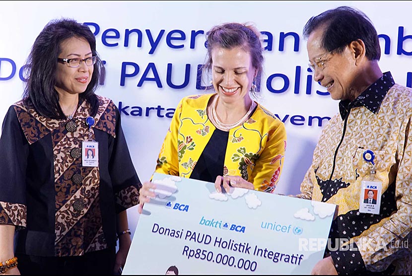 Presiden Direktur PT Bank Central Asia Tbk, Jahja Setiaatmadja (kanan) menyerahkan secara simbolis donasi  kepada Deputy Representative UNICEF, Lauren Rumble disaksikan Executive Vice President CSR BCA, Inge Setiawati (kiri) di Jakarta, Senin (20/11). Melalui program Bakti BCA ,kembali berpartisipasi mendukung peningkatan kualitas pendidikan anak usia dini 