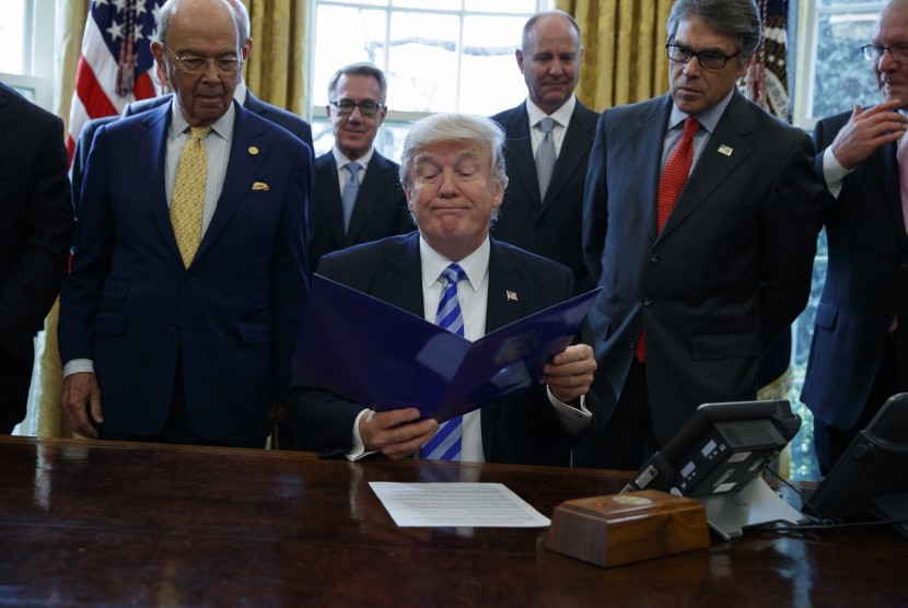 Presiden Donald Trump bersama Menteri Perdagangan Wilbur Ross (kiri) dan Menteri Energi Rick Perry di Oval Office Gedung Putih di Washington.