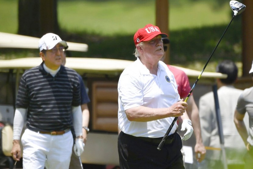 Presiden Donald Trump (kanan) bermain golf dengan PM Jepang, Shinzo Abe, di Mobara Country Club di Mobara, selatan Tokyo, Ahad (26/5).