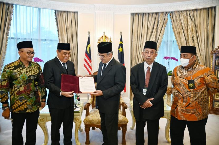 Presiden Dunia Melayu Dunia Islam (DMDI) Tun Sri Setia (DR) H Mohd Ali bin Mohd Rustam mengukuhkan Komjen (Purn) Syafruddin sebagai wakil presiden DMDI di Melaka, Malaysia, Rabu (13/4/2022). 