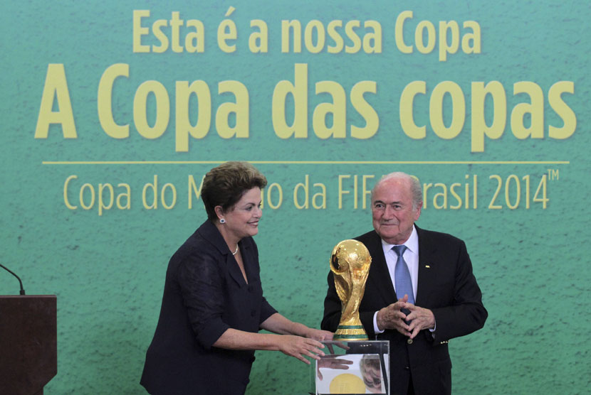Presiden FIFA, Sepp Blatter (kanan), dan Presiden Brasil, Dilma Rousseff, berpose bersama trofi Piala Dunia di Planalto Palace, Brasilia, Senin (2/6). 
