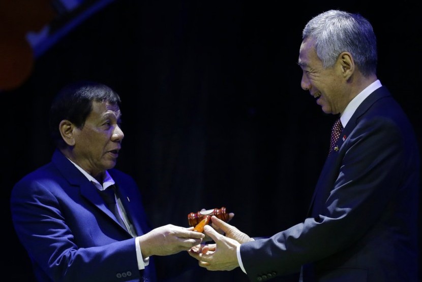 Presiden Filipina Rodrigo Duterte menyerahkan keketuaan ASEAN kepada Perdana Menteri Singapura Lee Hsien Loong saat penutupan KTT ASEAN ke-31 di Manila, Filipina, Selasa (14/11).