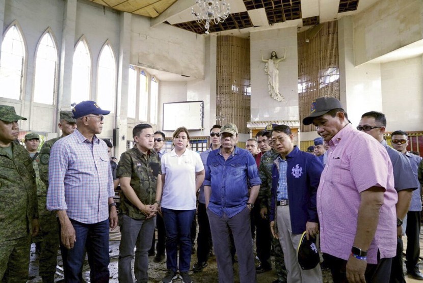 Presiden Filipina Rodrigo Duterte (tengah) mengunjungi Gereja Katedral Katolik di Jolo, Provinsi Sulu, Filipina, Senin (28/1). Kunjungan dilakukan dua hari setelah dua bom meledak saat Misa Ahad. 