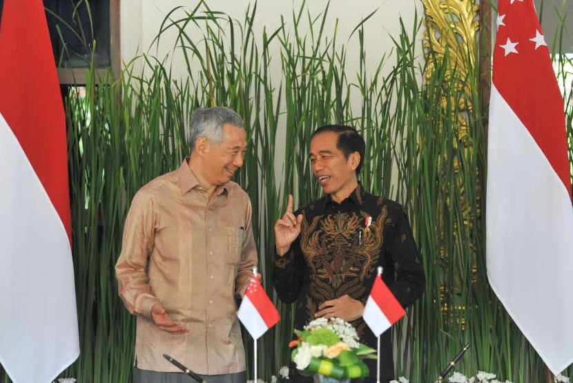 Indonesian President Joko Widodo (right) talks with Singapore Prime Minister Lee Hsien Loong (left) before the signing of bilateral cooperation between Indonesian and Singaporean ministers, on the sidelines of the IMF Annual Meeting - World Bank Group 2018 in Nusa Dua, Bali, Thursday (Oct 11).