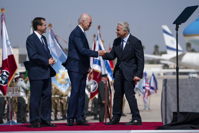Presiden Israel Isaac Herzog, kiri, melihat saat Presiden Joe Biden meninju Perdana Menteri Israel Yair Lapid selama upacara kedatangan setelah tiba di Bandara Ben Gurion, Rabu, 13 Juli 2022, di Tel Aviv.