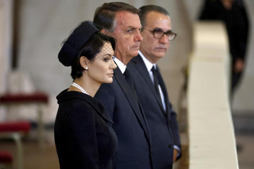 Presiden Jair Bolsonaro dari Brasil, tengah, dan istrinya Michelle memberikan penghormatan kepada Ratu Elizabeth II saat disemayamkan di State di dalam Westminster Hall, di Istana Westminster di London, Minggu, 18 September 2022.
