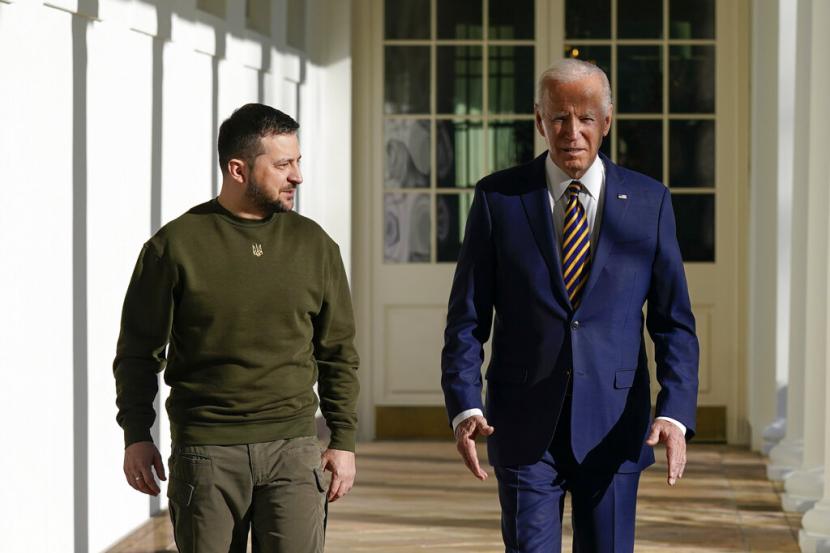 Presiden Joe Biden dan Presiden Ukraina Volodymyr Zelenskyy berjalan di sepanjang barisan tiang Gedung Putih, Rabu, 21 Desember 2022, di Washington.