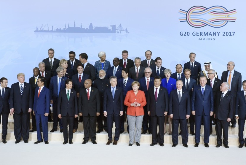 Presiden Joko Widodo (baris depan, ketiga dari kiri) tampak berbincang dengan Presiden Prancis Emmanuel Macron (baris depan, paling kiri) dalam sesi foto bersama pemimpin negara G20 di Hamburg, Jerman, 7 Juli 2017.