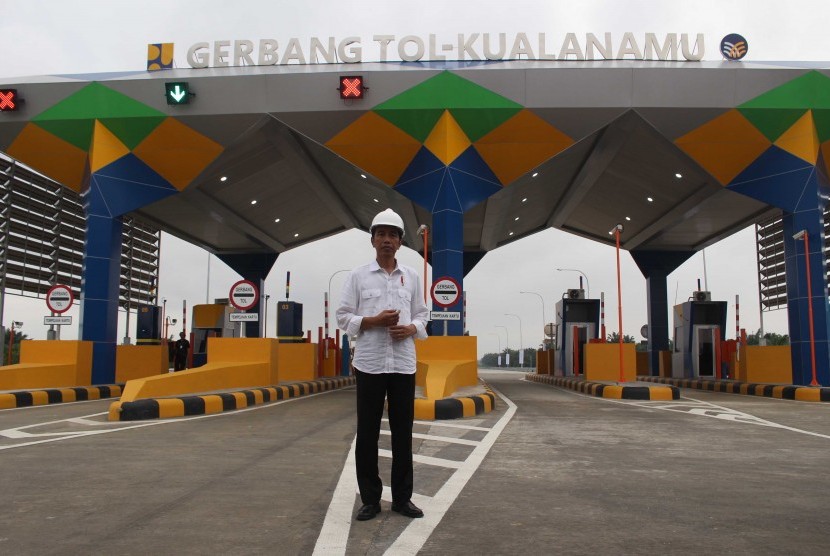 Presiden Joko Widodo berdiri di depan pintu masuk tol ketika meninjau Jalan Tol Trans Sumatera ruas gerbang tol Kualanamu saat diresmikan di Deli Serdang, Sumatera Utara, Jumat (13/10). 
