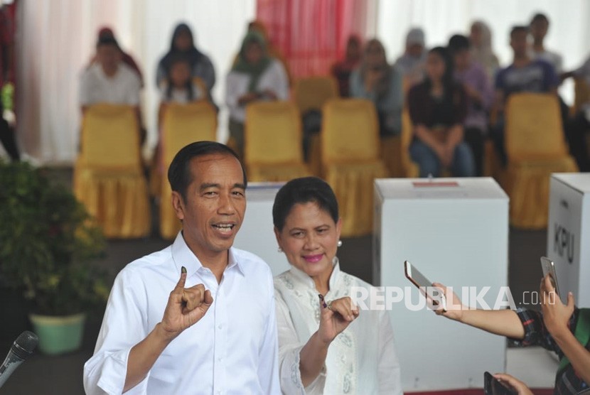 Presiden Joko Widodo bersama Ibu Iriana Joko Widodo menggunakan hak suaranya di TPS 008, Kelurahan Gambir, Kecamatan Gambir, Jakarta Pusat, Rabu (17/4).