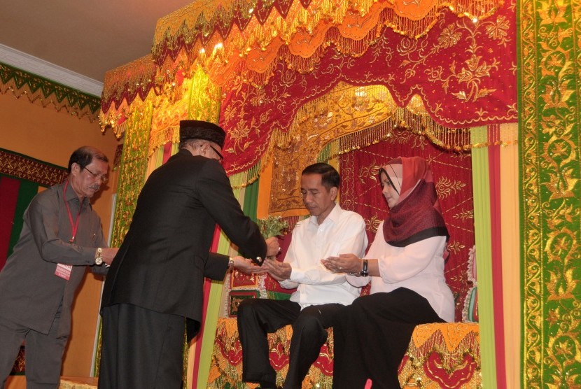  Presiden Joko Widodo bersama ibu negara, Iriana Joko Widodo, duduk di pelaminan saat di Peusijuk secara adat oleh Wali Nanggroe Aceh, Malik Mahmud (keud kiri) di Pendopo Gubernuran, Banda Aceh, Senin (9/3). (Antara/Ampelsa)