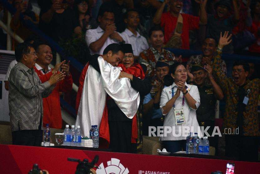 President Joko Widodo and Chairman of Indonesian Pencak Silat Association Prabowo Subianto embraced by gold medalist Hanifan Yudani Kusuma at Padepokan Pencak Silat Taman Mini Indonesia Indah, East Jakarta, on Wednesday (August 29).