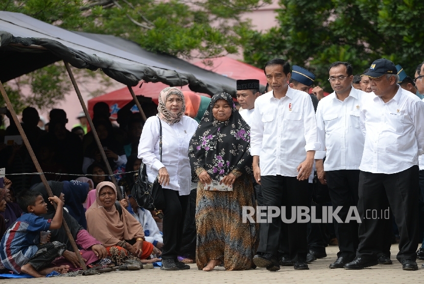 Presiden Joko Widodo bersama pengungsi saat mengunjungi tempat pengungsian korban gempa di Meureudu, Pidie Jaya, NAD, Jumat (9/12).