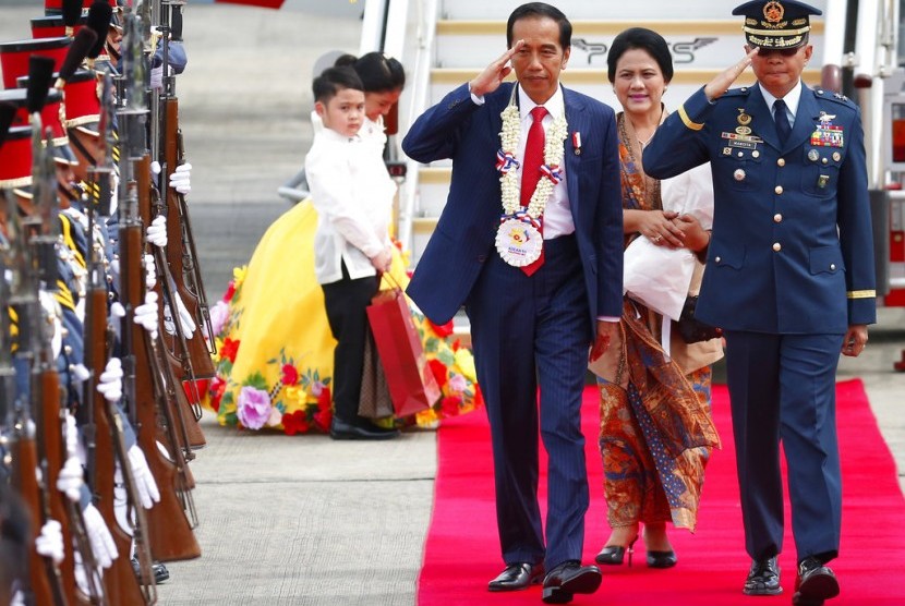 Indonesian President Joko Widodo, center, salutes the troops upon arrival at Clark International Airport in Clark, Pampanga province, north of Manila, Philippines Sunday, Nov. 12, 2017. 