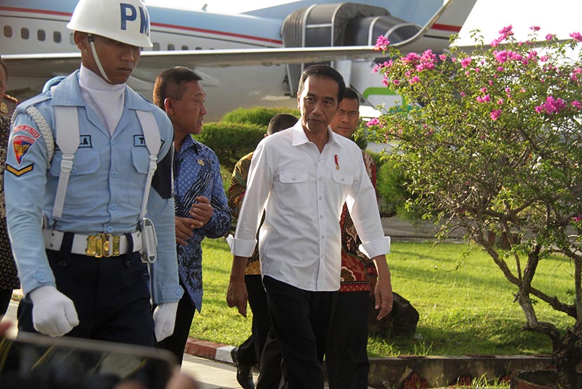 Presiden Joko Widodo didampingi Plt Gubernur Aceh, Soedarmo (kedua kiri) berjalan bersama saat tiba di Bandara Sultan Iskandar Muda, Aceh Besar, Aceh, Kamis (8/12). 