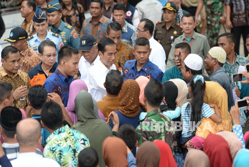 Presiden Joko Widodo emnyalami masyarakat saat mengunjungi tempat pengungsian korban gempa di Meureudu, Pidie Jaya, NAD, Jumat (9/12).