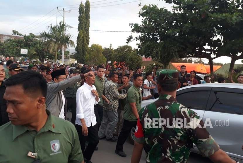 Presiden Joko Widodo (Jokowi) bersama Gubernur NTB TGB Zainul Majdi meninjau posko utama penanganan darurat bencana di lapangan Tanjung, Kabupaten Lombok Utara, NTB, Senin (13/8).