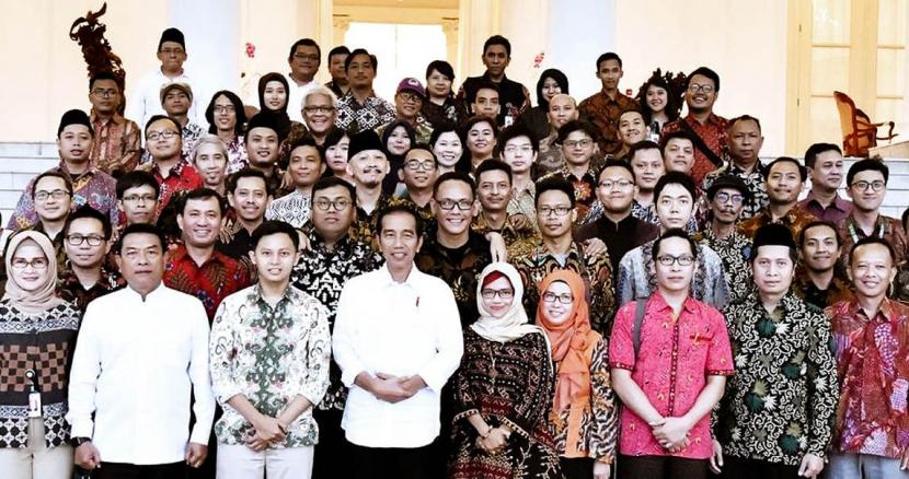 Presiden Joko Widodo (Jokowi) ditemani Kepala Staf Presiden (KSP) Jenderal (Purn) Moeldoko berfoto bersama puluhan pegiat medsos, termasuk Permadi Arya alias Abu Janda, Denny Siregar, Eko Kuntadhi, hingga Sahal AS, yang dijuluki warganet sebagai buzzer.
