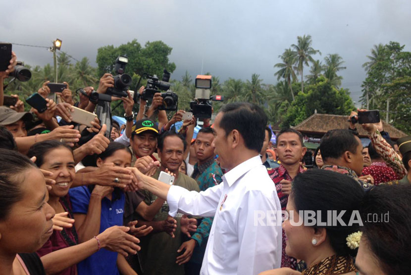 Presiden Joko Widodo (Jokowi) memberikan bantuan kepada para pengungsi erupsi Gunung Agung di lapangan Desa Ulakan, Karangasem, Bali, Selasa (26/9). 