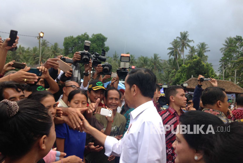 Presiden Joko Widodo (Jokowi) memberikan bantuan kepada para pengungsi erupsi Gunung Agung di lapangan Desa Ulakan, Karangasem, Bali, Selasa (26/9). 