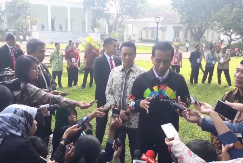 President Joko Widodo (Jokowi) wears jacket bearing the Asian Games 2018 logo when receiving representatives of high school student organization (OSIS), at the Bogor Presidential Palace, West Java Province, Thursday. 