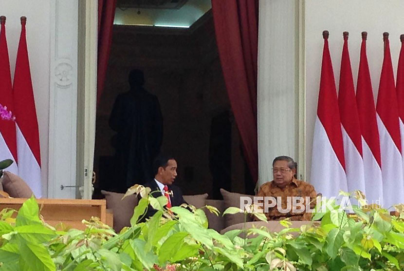 Presiden Joko Widodo (Jokowi) berbincang dengan Presiden ke-RI Susilo Bambang Yudhoyono (SBY) di veranda halaman tengah Istana, Jakarta, Jumat (27/10). 