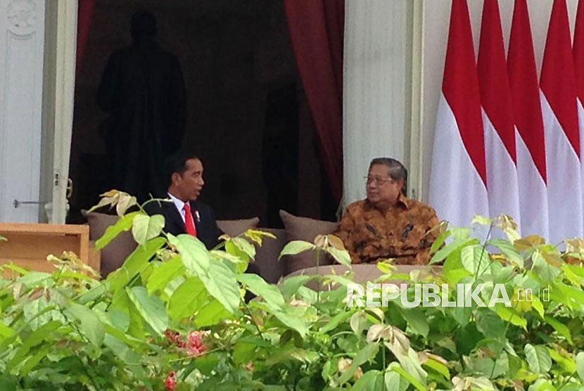 Presiden Joko Widodo (Jokowi) tengah berbincang dengan Presiden keenam Susilo Bambang Yudhoyono (SBY) di veranda halaman tengah Istana, Jakarta, Jumat (27/10). 