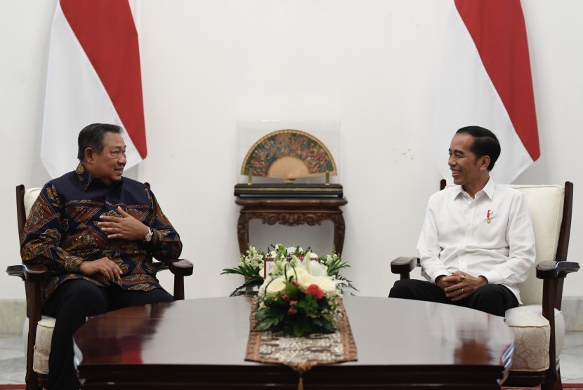 Presiden Joko Widodo (kanan) berbincang dengan mantan Presiden Susilo Bambang Yudhoyono dalam pertemuan di Istana Merdeka, Jakarta, Kamis (10/10).