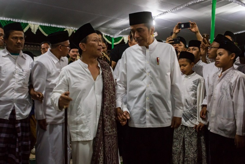 Presiden Joko Widodo (kanan) berbincang dengan pengasuh Pondok Pesantren Girikesumo KH Munif Zuhri (kiri) saat berkunjung ke pesantren tersebut di Desa Banyumeneng, Mranggen, Demak, Jawa Tengah, Jumat (19/10/2018).