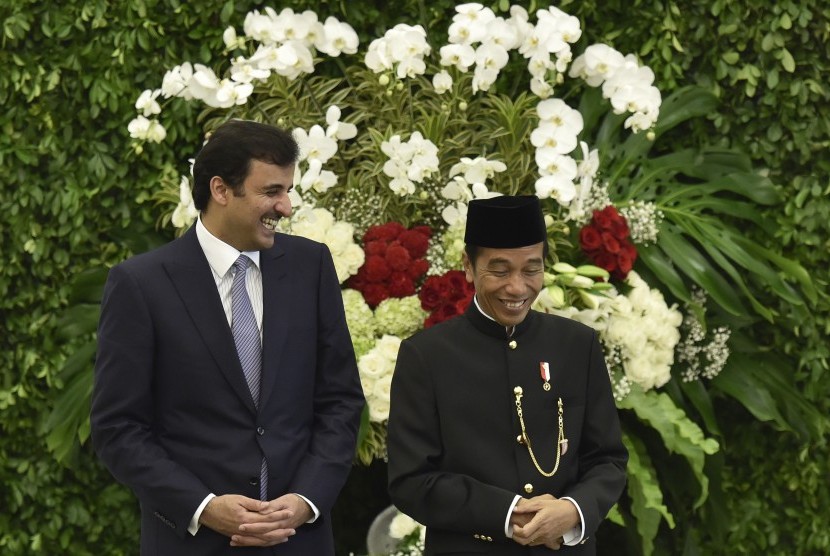 Presiden Joko Widodo (kanan) bersama Emir Qatar Sheikh Tamim bin Hamad Al Thani (kiri) tertawa disela-sela menyaksikan penandatanganan kerja sama kedua negara di Istana Bogor, Jawa Barat, Rabu (18/10).