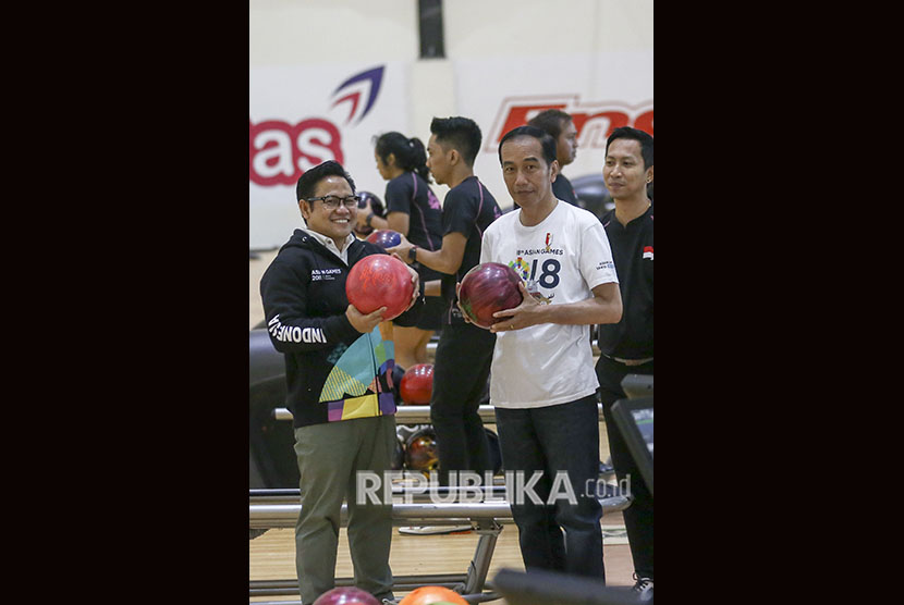 Presiden Joko Widodo (kanan) bersama Panglima Santri Nusantara Muhaimin Iskandar (kiri) mengangkat bola boling saat mencoba lintasan arena Jakabaring Boling Center, Palembang, Sumateran Selatan, Sabtu (14/7). 