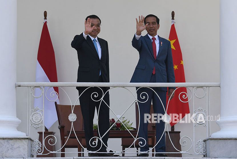 Presiden Joko Widodo (kanan) bersama Perdana Menteri Cina Li Keqiang (kiri) melambaikan tangan kepada jurnalis di beranda Istana Bogor, Jawa Barat, Senin (7/5). 