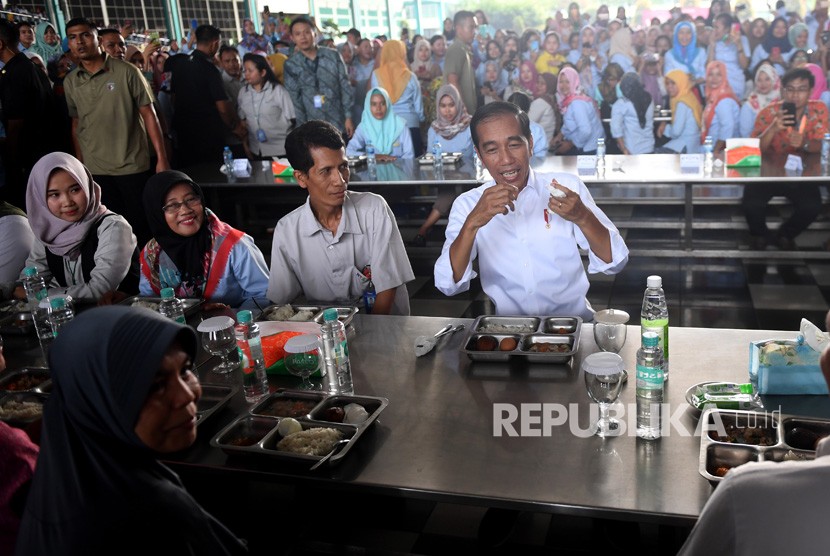 Presiden Joko Widodo (kanan) bersiap untuk makan bersama saat mengunjungi pabrik sepatu PT KMK Global Sports I, Tangerang, Banten, Selasa (30/4/2019).