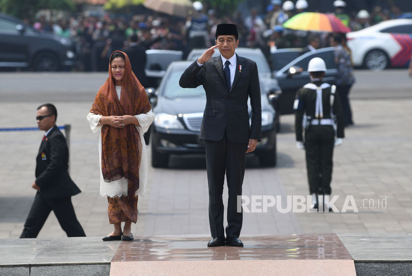 Presiden Joko Widodo (kanan) beserta Ibu Negara Iriana Joko Widodo (kiri) memberi hormat saat tiba untuk memimpin prosesi pemakaman almarhum Presiden ke-3 Republik Indonesia BJ Habibie di Taman Makam Pahlawan Nasional Utama (TMP) Kalibata, Jakarta, Kamis (12/9/2019).