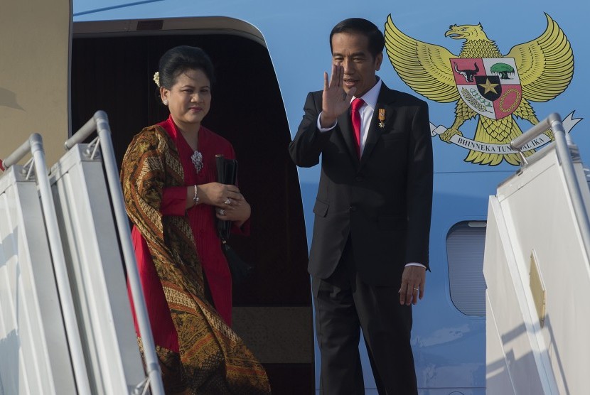 Presiden Joko Widodo (kanan) dan Ibu Negara Ny. Iriana Widodo melambaikan tangan sebelum masuk ke pesawat kepresidenan di Bandara Internasional Halim Perdanakusuma, Jakarta Timur, Selasa (28/7). 