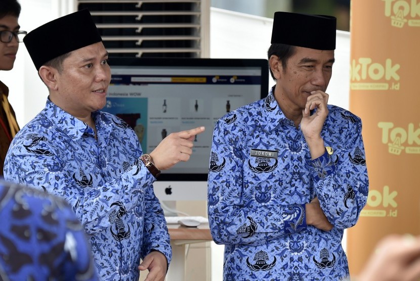 Presiden Joko Widodo (kanan) didampingi Ketua Umum Dewan Pimpinan Nasional Korpri, Zudan Arif Fakhrulloh (kiri) meninjau stan toko online KORPRI disela-sela peringatan HUT ke-45 KORPRI di Monumen Nasional, Jakarta, Selasa (29/11).