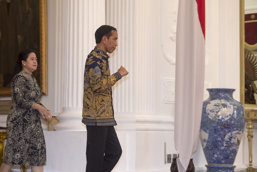 Presiden Joko Widodo (kanan) didampingi Menko PMK Puan Maharani (kiri) berjalan menuju ruang jumpa pers di Istana Merdeka, Jakarta, Kamis (10/3). 